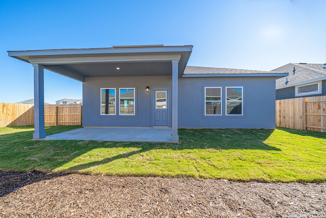 back of property with a patio and a lawn