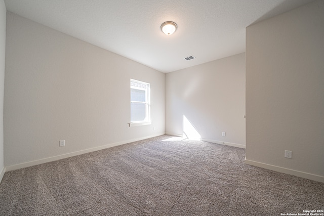 carpeted spare room featuring a textured ceiling