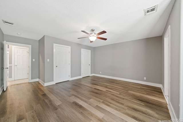 interior space featuring hardwood / wood-style flooring, a textured ceiling, and ceiling fan