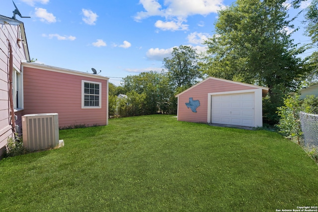 view of yard with a garage, an outdoor structure, and central air condition unit