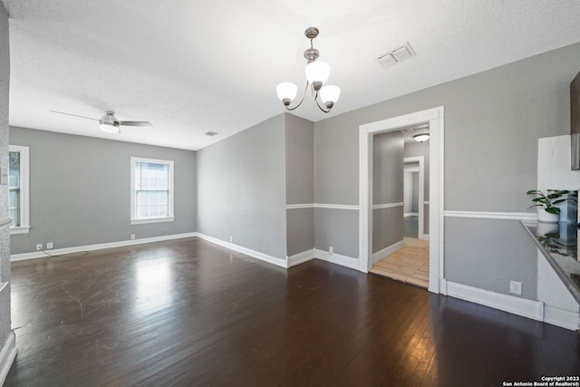 unfurnished room with ceiling fan with notable chandelier, dark hardwood / wood-style flooring, and a textured ceiling