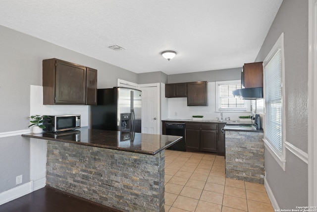 kitchen featuring light tile patterned flooring, kitchen peninsula, dark brown cabinets, and stainless steel appliances