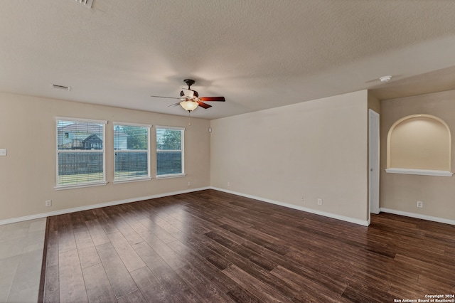 spare room featuring ceiling fan, a textured ceiling, and dark wood-type flooring