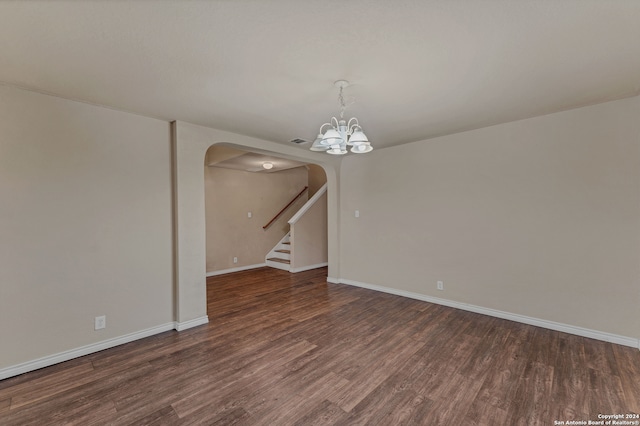 unfurnished room featuring a chandelier and dark hardwood / wood-style flooring