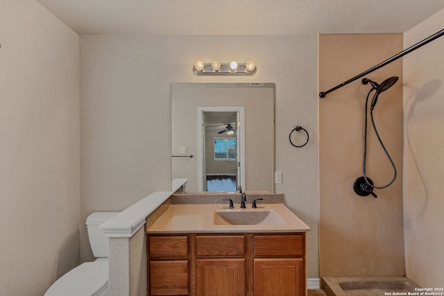 bathroom featuring ceiling fan, vanity, toilet, and a shower