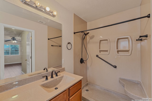 bathroom with ceiling fan, walk in shower, and vanity