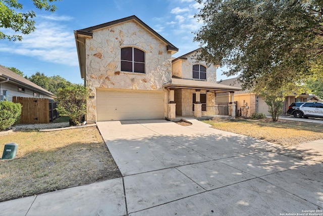 235 Hondo Dr, New Braunfels, TX 78130 - french country style house featuring stone siding, a porch, an attached garage, concrete driveway, and fence
