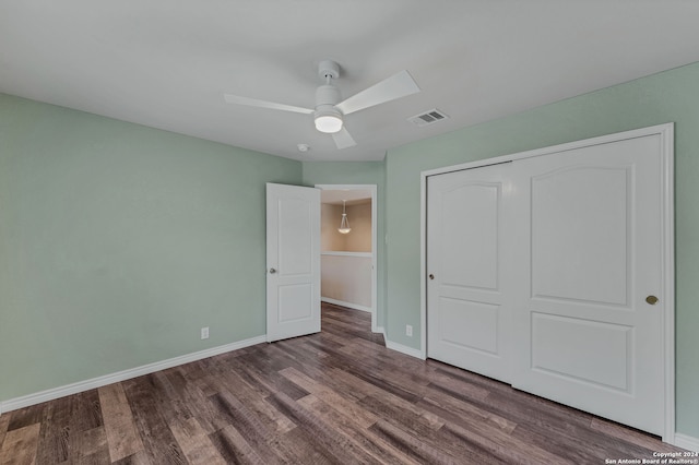 unfurnished bedroom with ceiling fan, a closet, and hardwood / wood-style floors