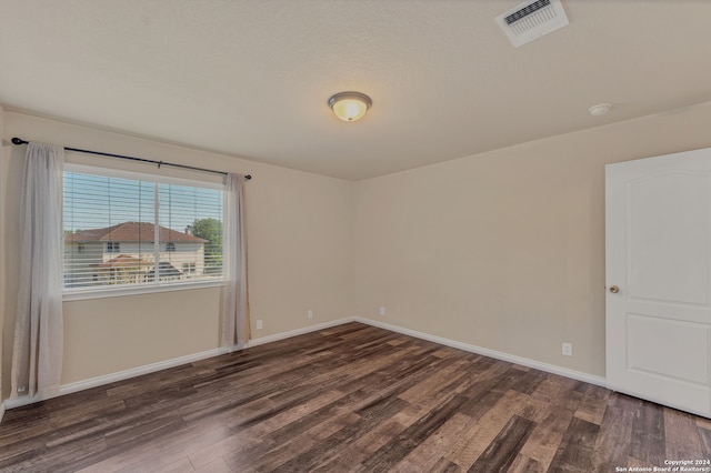 spare room featuring dark wood-type flooring