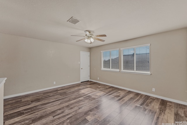 unfurnished room featuring ceiling fan, a textured ceiling, and dark wood-type flooring