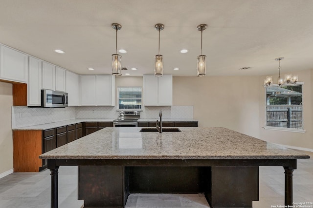 235 Hondo Dr, New Braunfels, TX 78130 - kitchen featuring appliances with stainless steel finishes, a sink, tasteful backsplash, light stone counters, and recessed lighting