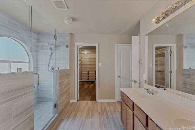 bathroom with wood-type flooring, vanity, and a shower with shower door