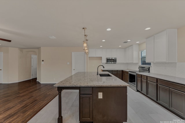 kitchen featuring light hardwood / wood-style floors, sink, stainless steel appliances, hanging light fixtures, and white cabinetry