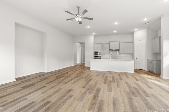 unfurnished living room with ceiling fan and light hardwood / wood-style flooring