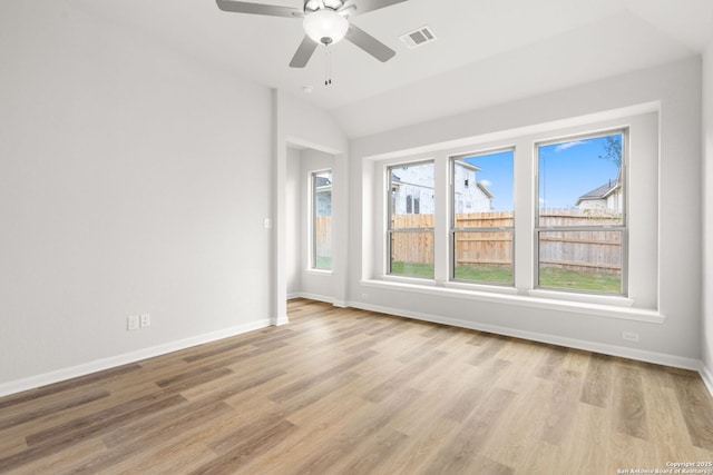 spare room with ceiling fan, light wood-type flooring, and vaulted ceiling