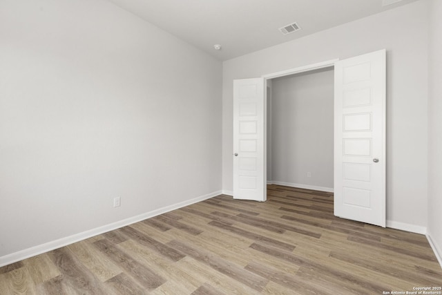 unfurnished bedroom with wood-type flooring and a closet