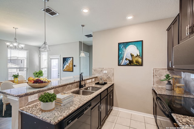 kitchen with light stone counters, dishwasher, sink, pendant lighting, and backsplash