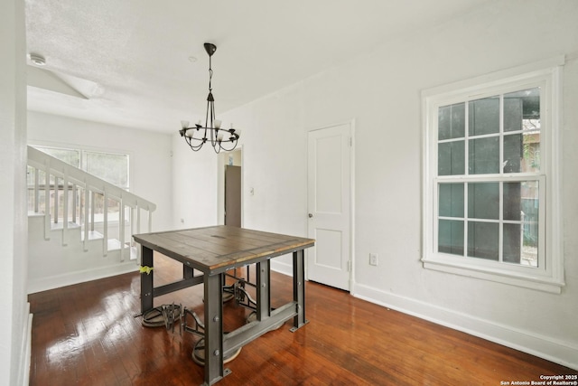 dining room featuring dark hardwood / wood-style flooring and an inviting chandelier