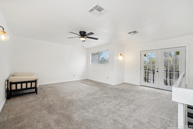 unfurnished living room with carpet flooring, ceiling fan, a wealth of natural light, and french doors