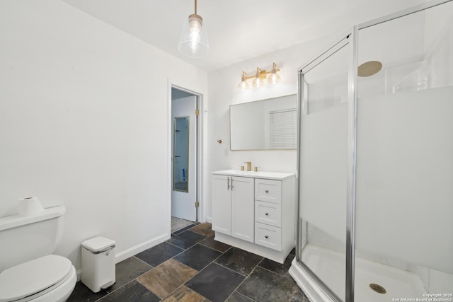 bathroom featuring vanity, toilet, and a shower with shower door