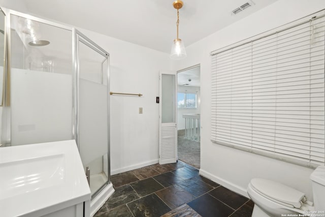 bathroom featuring vanity, toilet, and an enclosed shower