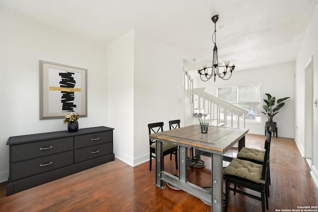 dining area featuring dark hardwood / wood-style flooring and an inviting chandelier