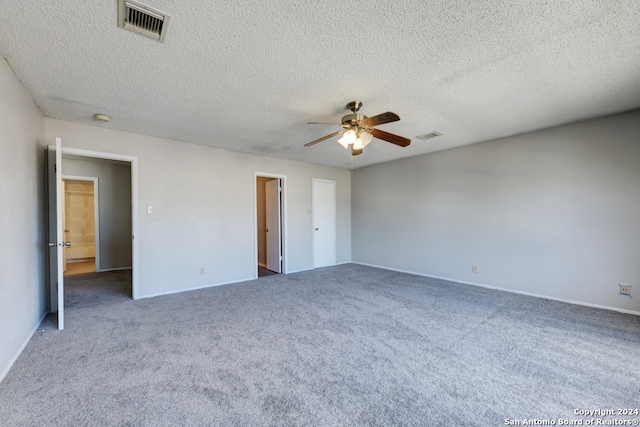 unfurnished bedroom featuring dark colored carpet, a textured ceiling, and ceiling fan