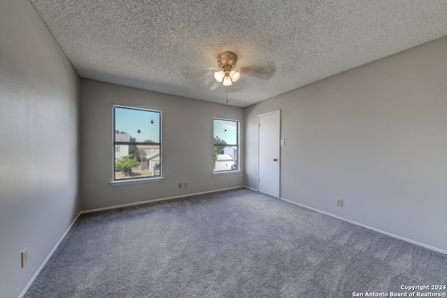 carpeted empty room with a textured ceiling and ceiling fan