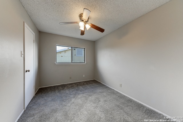 empty room with ceiling fan, carpet flooring, and a textured ceiling