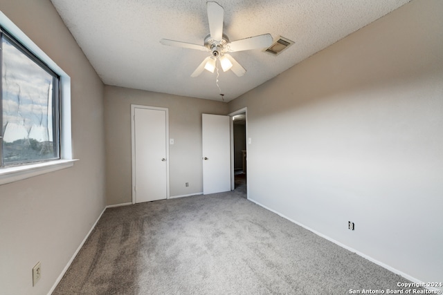 unfurnished bedroom featuring a textured ceiling, carpet flooring, and ceiling fan