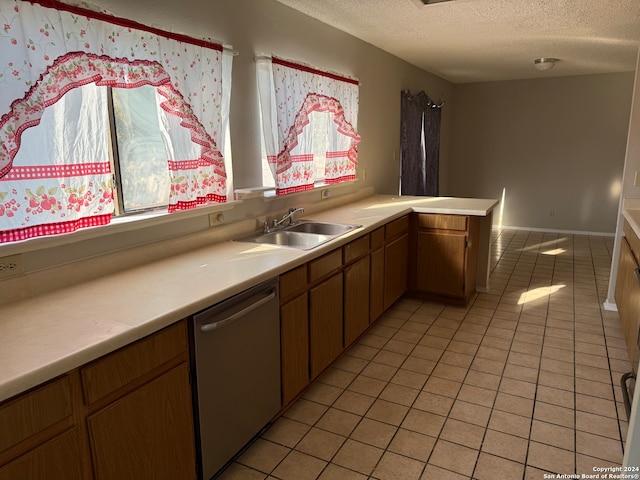 kitchen with sink, dishwasher, a textured ceiling, kitchen peninsula, and light tile patterned floors