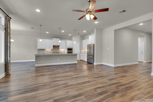 unfurnished living room featuring ceiling fan and hardwood / wood-style floors