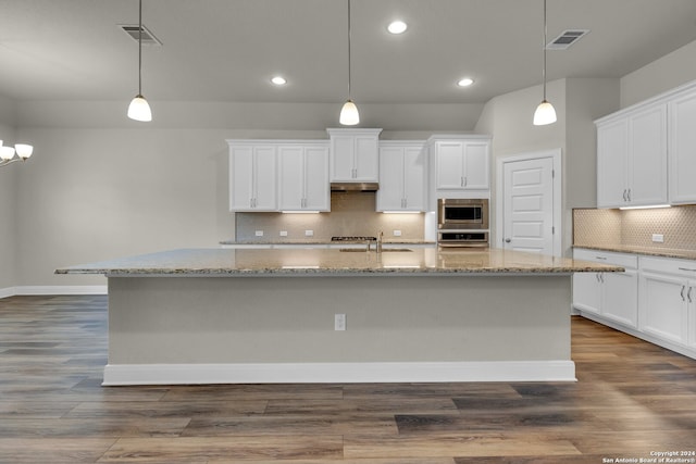 kitchen featuring a center island with sink, white cabinets, pendant lighting, and appliances with stainless steel finishes