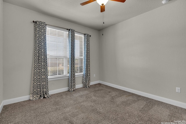 carpeted spare room with a wealth of natural light, ceiling fan, and a textured ceiling