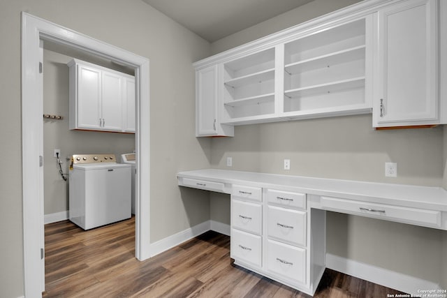 unfurnished office with washing machine and dryer, built in desk, and dark hardwood / wood-style floors