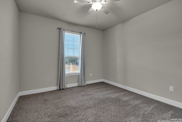 carpeted spare room featuring ceiling fan