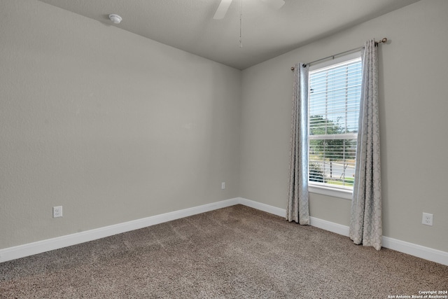 carpeted spare room featuring ceiling fan