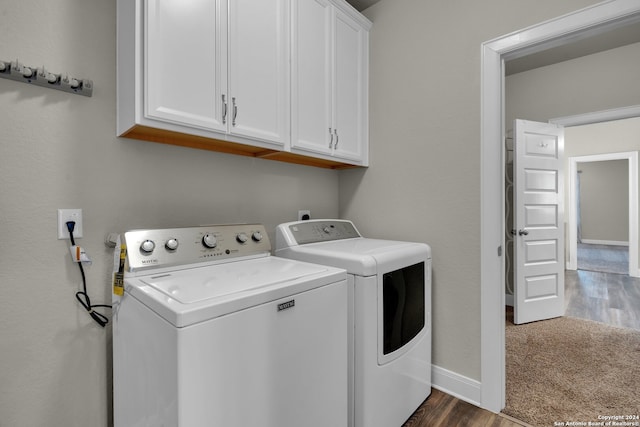 washroom with cabinets, dark hardwood / wood-style flooring, and washing machine and clothes dryer