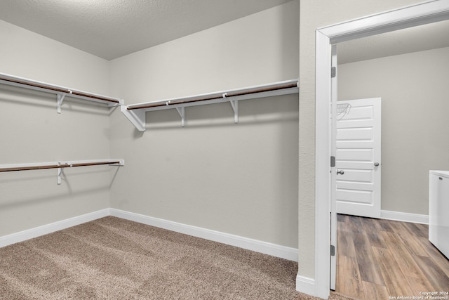 walk in closet with hardwood / wood-style flooring