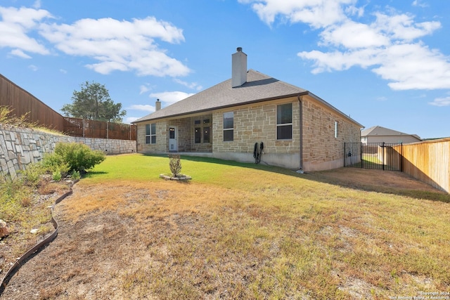 rear view of property featuring a lawn