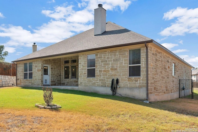 rear view of house featuring a yard