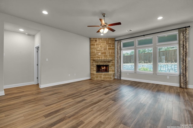 unfurnished living room featuring a fireplace, wood-type flooring, and ceiling fan