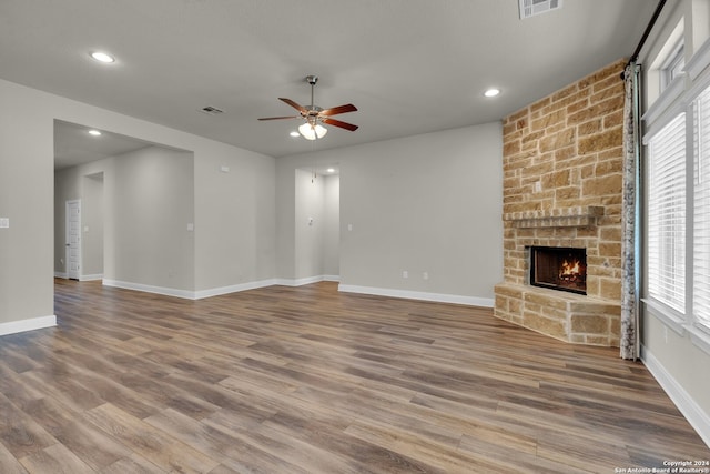 unfurnished living room featuring a wealth of natural light, a fireplace, and wood-type flooring