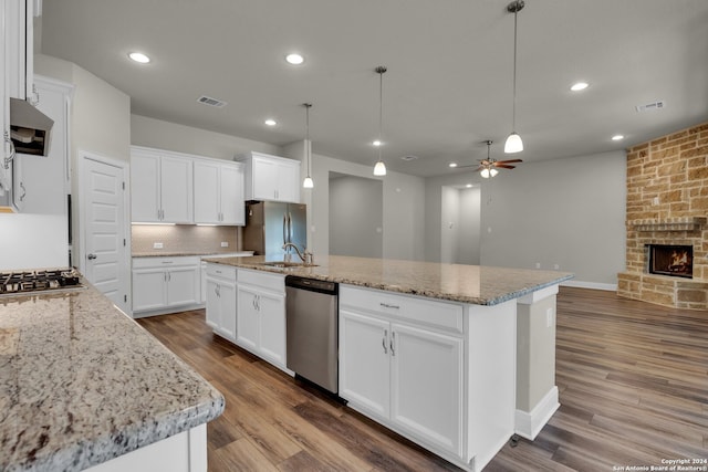 kitchen featuring a center island with sink, white cabinetry, and stainless steel appliances