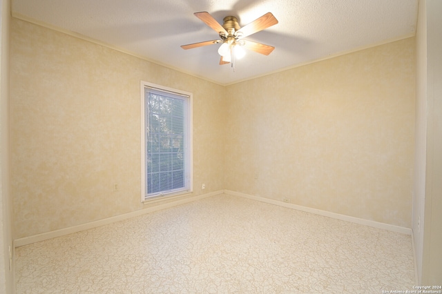 unfurnished room with ceiling fan and a textured ceiling