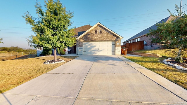 view of front of home featuring fence, driveway, a front yard, and a garage