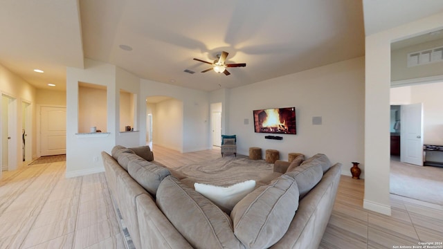living room with a ceiling fan, visible vents, arched walkways, and recessed lighting
