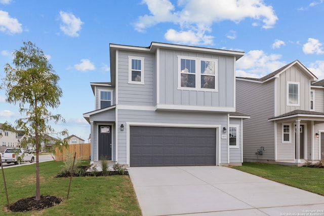 view of front of property featuring a front yard and a garage