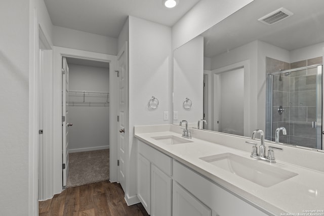 bathroom with walk in shower, vanity, and hardwood / wood-style floors