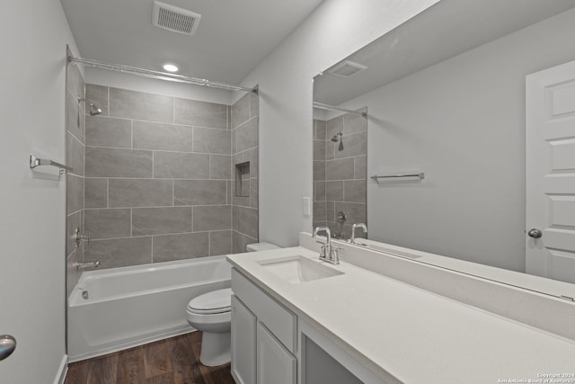 full bathroom with vanity, toilet, wood-type flooring, and tiled shower / bath combo